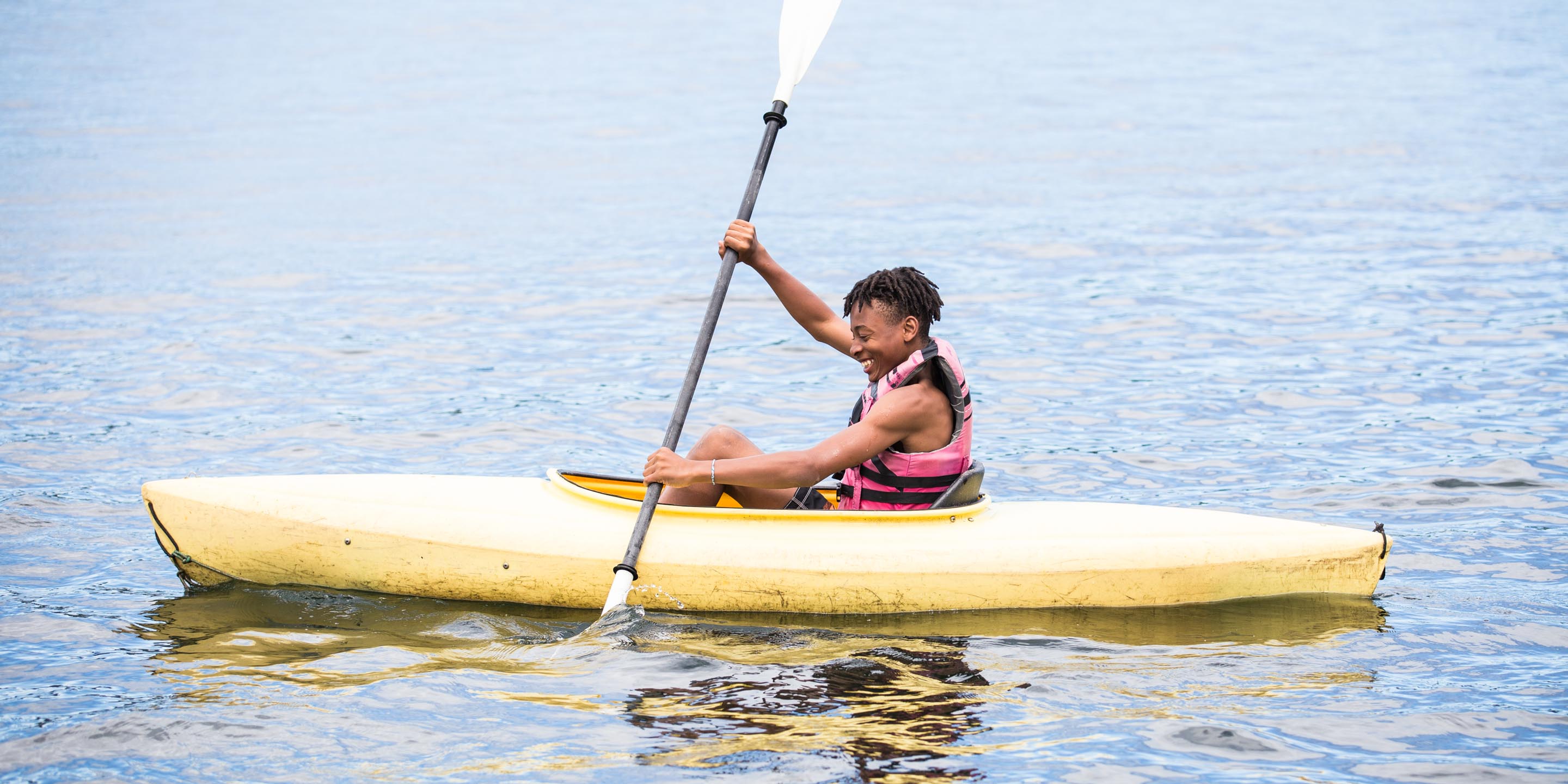 Boy kayaks at summer camp