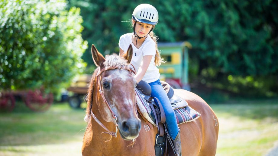 Girl rides horse at summer camp